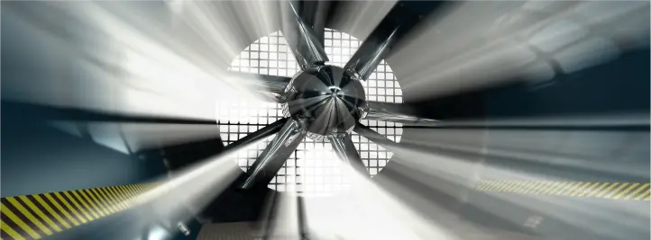 Close-up view of a jet engine turbine with rotating blades inside the nacelle, captured with motion blur from a head-on perspective.