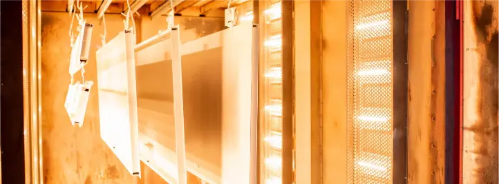 Interior of a tanning booth with vertical UV lights along the side and warm orange lighting